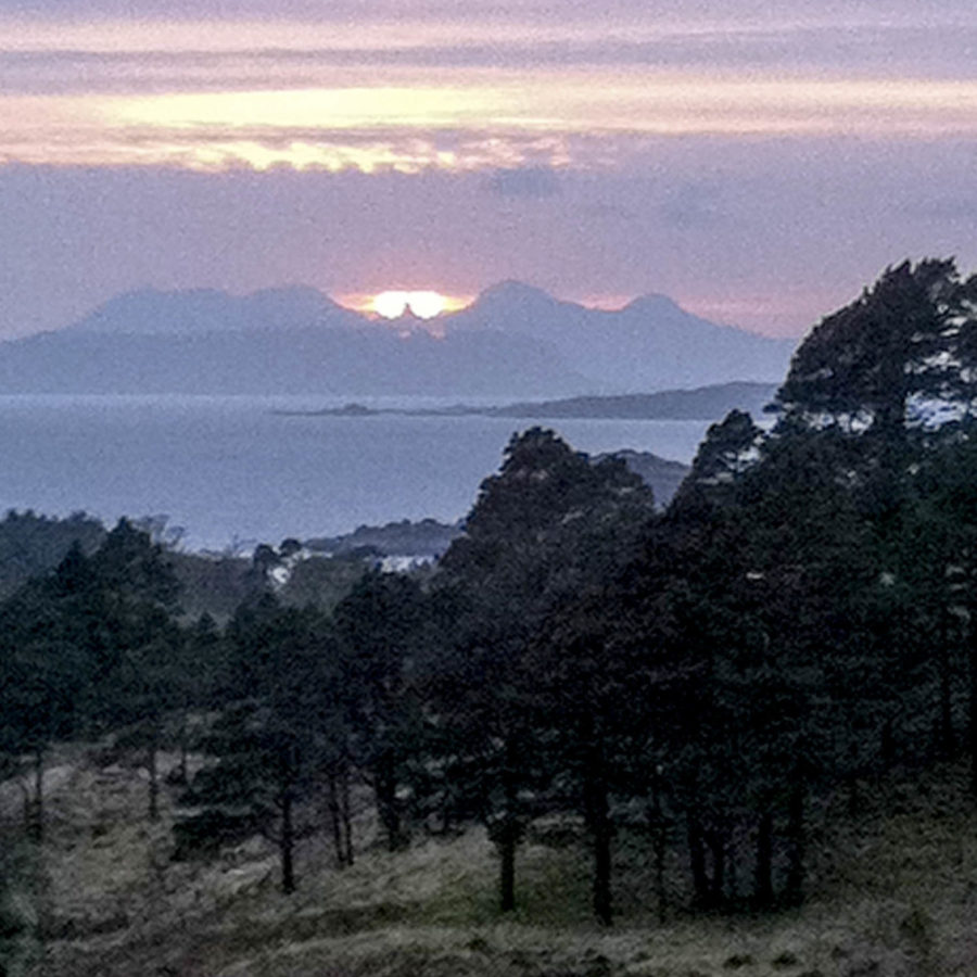 Beltane Sunset over Trallval, with the rock of Eilean à Ghaill and its vitrified fort in the middle-distance. Image credit: Alasdair Gray.