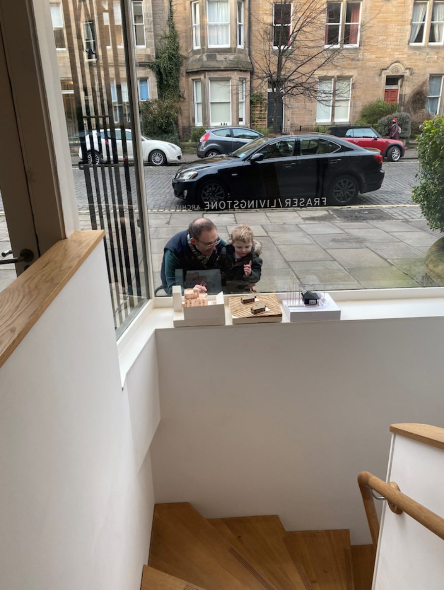 Father and son looking at architectural models in the window