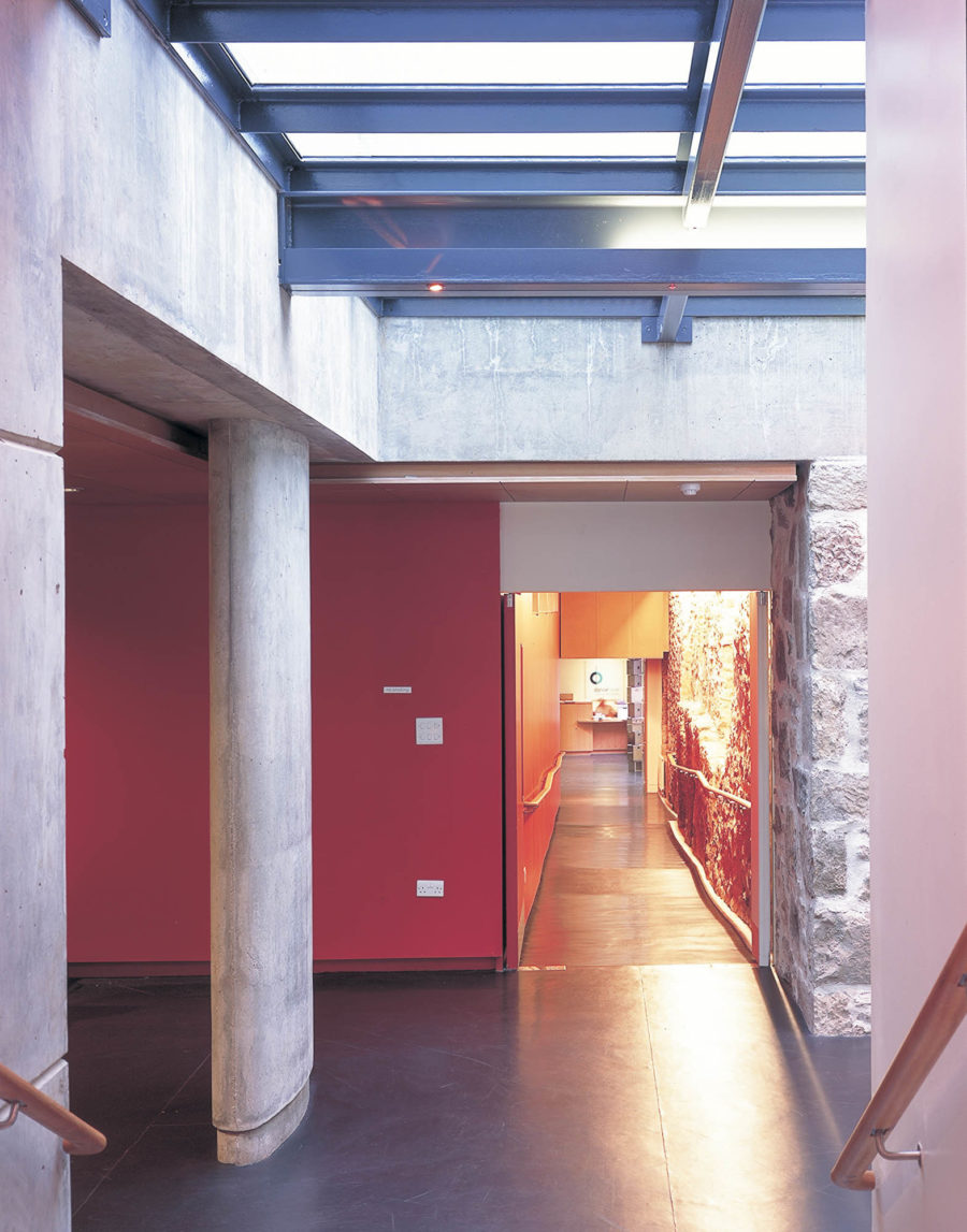 Rooflit corridor with concrete pillar and exposed stonework, DanceBase Edinburgh. Malcolm Fraser Architects.